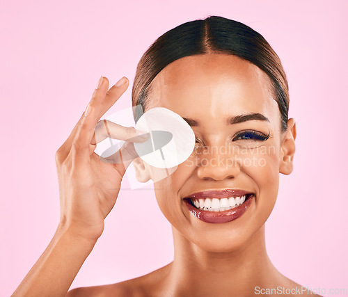 Image of Happy woman, face and cotton pad in makeup removal, skincare or cosmetics against a pink studio background. Portrait of excited female person with cosmetic swab in beauty cleaning or facial treatment