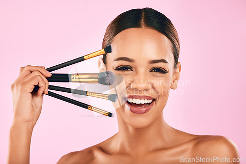 Image of Happy woman, portrait smile and makeup brushes for beauty cosmetics against a pink studio background. Isolated female person or model smiling in satisfaction for cosmetic tools, grooming or facial