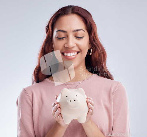 Image of Finance, portrait or happy girl with a piggy bank for financial wealth or savings on white background. Smile, investment or woman smiling or investing cash or budget in tin for safety or security