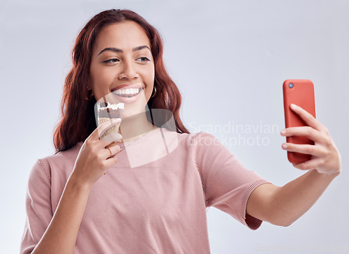 Image of Girl, ice cream and selfie with smile in studio for summer vacation, social media app and blog by white background. Woman, gelato or dessert with photography, profile picture and happy by backdrop