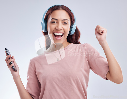 Image of Mobile, portrait or happy woman in headphones dancing music or radio audio in studio on white background. Dance, singing or girl streaming or listening to song playlist in freedom with cellphone