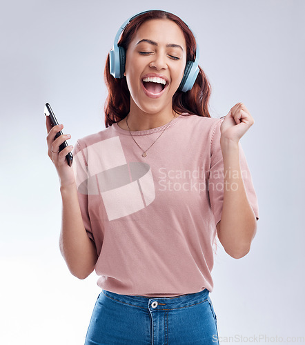 Image of Mobile, headphones or happy woman dancing to music or singing radio songs in studio on white background. Dance, smile or excited girl streaming or listening to audio playlist with cellphone or energy