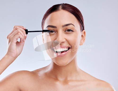 Image of Face, beauty and woman with mascara makeup, cosmetics and product brush on eye, lashes and studio background. Cosmetic, portrait and model with eyelashes tool for make up, dermatology and self care