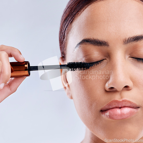 Image of Eyelash extension, beauty or girl with mascara makeup, cosmetics or product brush for grooming in studio. Face or closeup of woman with eyelashes tool for make up or self care on white background