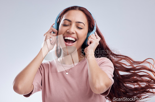 Image of Dance, headphones or happy woman singing music or radio audio smiling in studio on white background. Dancing, smile or excited gen z girl streaming or listening to online song playlist in freedom