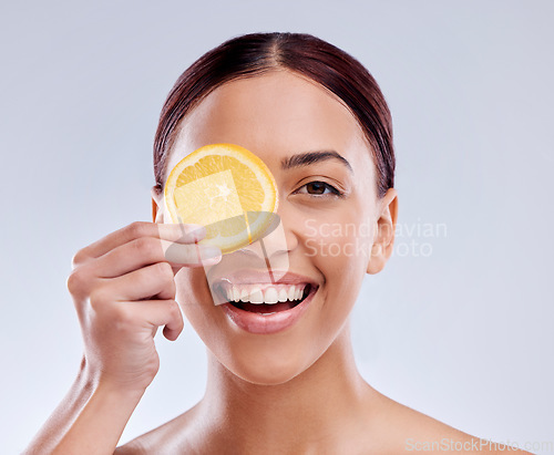 Image of Skincare, portrait or happy girl with orange or natural facial with citrus or vitamin c on studio background. Wellness, smile or healthy woman smiling with organic fruits for dermatology beauty