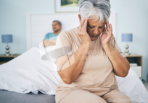 Image of Senior couple, bedroom and fight with a headache, retirement and relationship issue with pain, home and argument. Partners, mature man and elderly woman with a migraine, bed and angry with fatigue