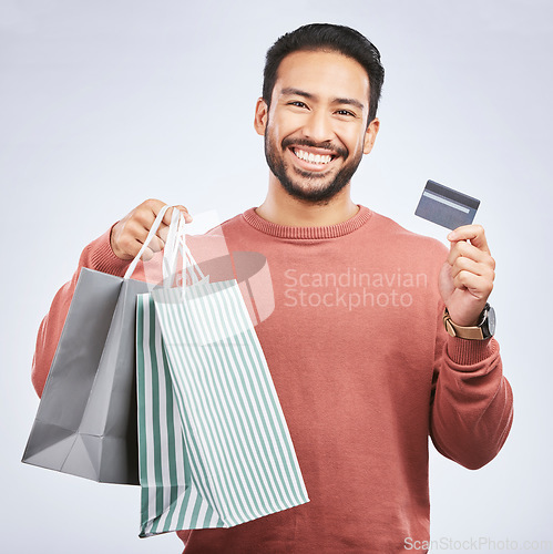 Image of Man with smile, shopping bag and credit card with retail, discount and commercial isolated on white background. Customer, finance and Asian male person with payment for purchase, luxury and sale