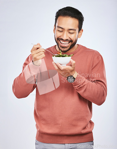 Image of Man is eating salad, healthy food and lose weight with nutrition, detox and vegetables isolated on studio background. Health, wellness and vitamins with hungry male person, eat meal and diet