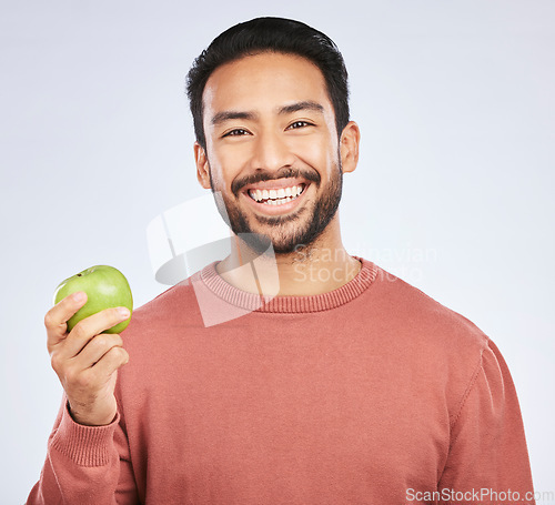 Image of Man in portrait, apple and nutrition with health and diet with eating isolated on white background. Male person with smile, green fruit and organic with healthy food, detox and lose weight in studio