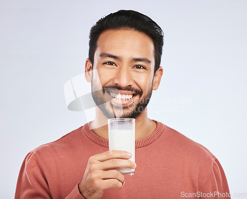 Image of Man with milk, drink and health with nutrition, calcium and vitamins with vanilla shake isolated on studio background. Dairy product in glass, beverage and male person smile, healthy and portrait