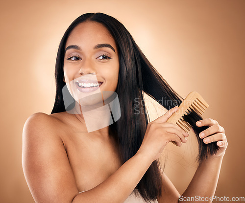 Image of Smile, woman brush her for hair treatment and against a studio background with a glow. Self care, health wellness and cheerful or excited isolated young female person brushing against backdrop