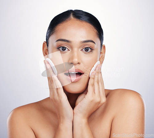 Image of Beauty, face and clean cotton on skin of woman in studio for natural dermatology and cosmetics. Female person with a skincare wipe in hand for health, wow review and wellness on a white background