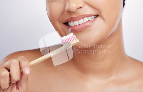 Image of Teeth, smile and woman with toothpaste on toothbrush, dental and oral hygiene isolated on studio background. Female model, happy with mouth care and cleaning, fresh breath with health and closeup