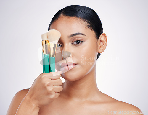 Image of Makeup brush, face and beauty with woman in portrait, foundation product and powder isolated on studio background. Female model, natural cosmetics and skin glow with cosmetic tools and cosmetology