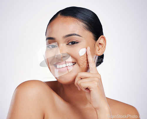 Image of Woman in portrait, cream on face and beauty with skincare, smile and moisturizer isolated on studio background. Happy female model apply lotion, dermatology and cosmetic product with skin glow