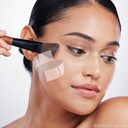 Image of Makeup, face brush and beauty of a woman in studio for skin glow, foundation or cosmetics. Headshot of a female model with cosmetic tools in hand for facial powder and shine on a white background