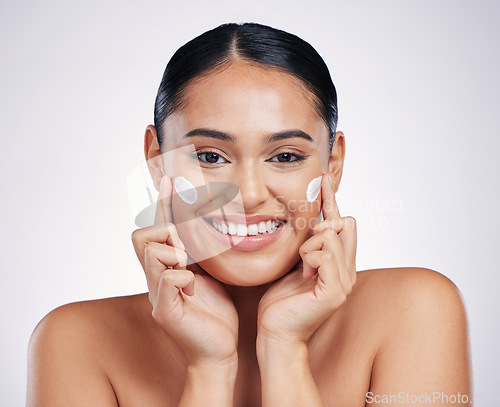 Image of Happy woman, portrait and smile with cream for skincare, moisturizer or cosmetics against a white studio background. Female person or model smiling for beauty skin product, lotion or facial treatment