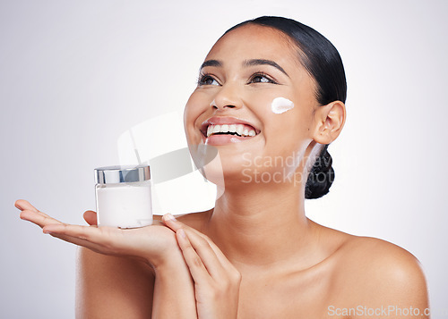 Image of Happy woman, face and thinking with cream in skincare, moisturizer or cosmetics against a white studio background. Female person model smiling for product, lotion or facial treatment on mockup space