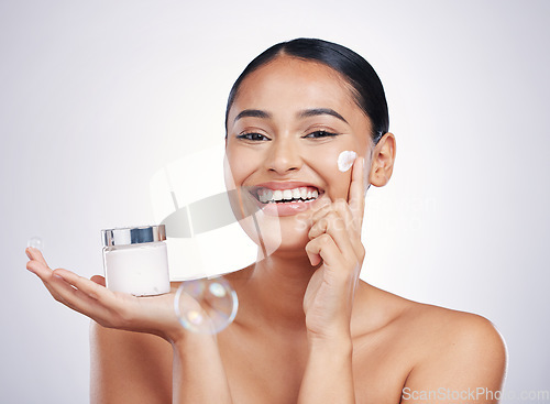 Image of Happy woman, portrait smile and cream in skincare, moisturizer or cosmetics against a white studio background. Female person or model smiling for product, lotion or facial treatment on mockup space