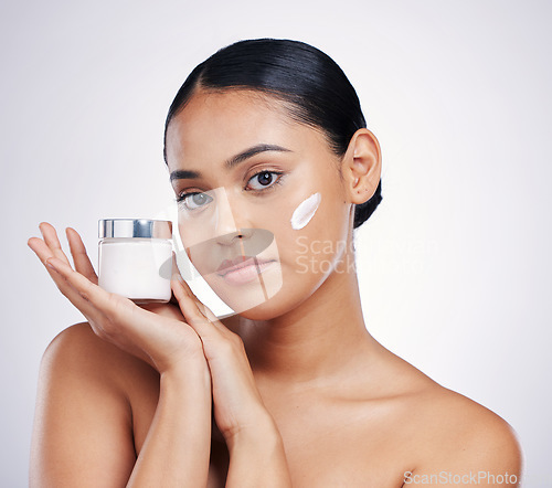Image of Face, beauty and skin cream for woman in studio for glow, dermatology and cosmetics. Portrait of female model with product container in hand for skincare, self care and wellness on a white background