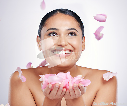 Image of Flower petals, face and beauty of a woman in studio for skin glow, dermatology and cosmetics. Female person with floral skincare in hand for facial shine, health and wellness on a white background