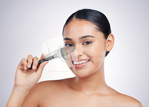 Image of Face roller, skin care and a woman in studio for beauty glow, dermatology or natural cosmetic. Portrait of happy female model with tools for facial massage and skincare benefits on a white background