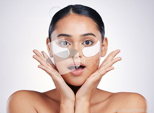 Image of Face, eye mask and a woman in studio for beauty glow, dermatology or natural cosmetics. Portrait of surprised person with skincare patch for facial self care with wow results on a white background