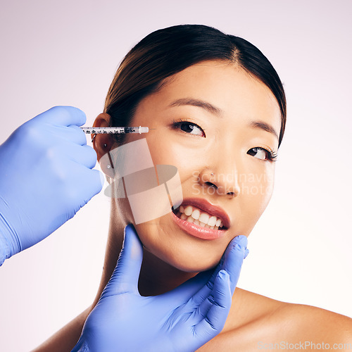 Image of Face injection, skincare and Asian woman in pain in studio isolated on a white background. Cosmetics, syringe and female model with collagen filler, dermatology and prp facelift in plastic surgery.