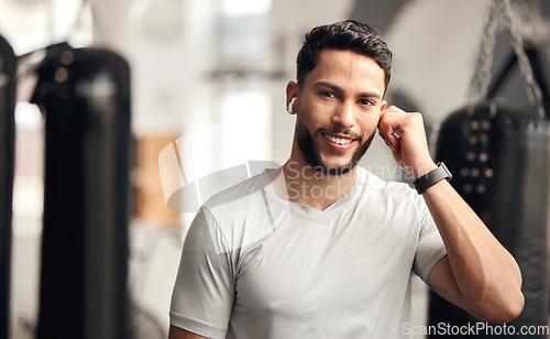 Image of Fitness, gym and a man with earphones for music for wellness, health and training with a smile. Face portrait of a person listening to audio, radio or podcast for exercise or workout at wellness club