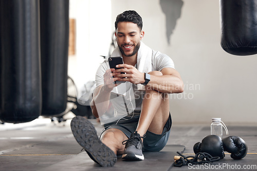 Image of Fitness, man with smartphone and earphones at the gym happy for training or health wellness. Meditation or commitment, exercise or workout and male athlete listen to music or podcast for motivation