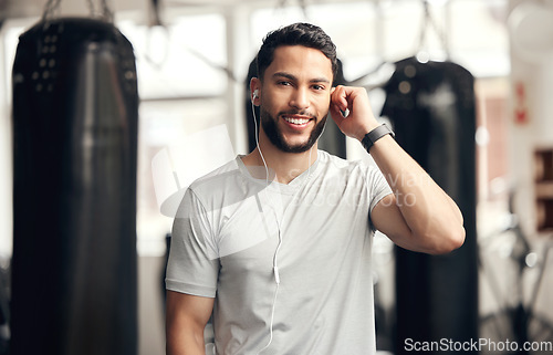 Image of Fitness, portrait of man with earphones and in gym happy for health wellness. Exercise or training, sportswear and smiling male athlete listening to music or podcast for motivation for workout.