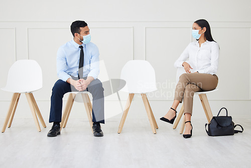 Image of Face mask, chair and business people waiting for interview, job vacancy and opportunity in office. Corporate, recruitment and man and woman talking, speaking and in conversation for hiring in covid