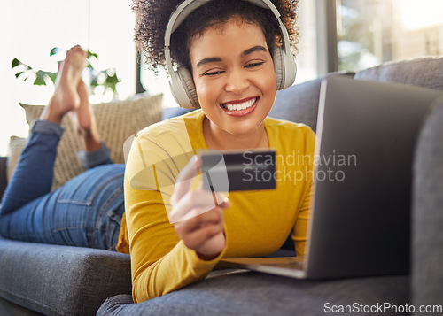 Image of Headphones, credit card and woman on computer for home online shopping, e commerce or fintech payment on sofa. Relax, music and happy african person on internet banking, audio subscription and laptop