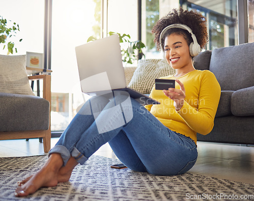 Image of Headphones, credit card and woman on laptop for home online shopping, ecommerce or fintech payment on floor. Relax, music and happy african person on internet banking, audio subscription and computer