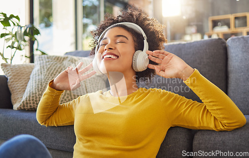 Image of Headphones, music and happy woman with mental health, wellness dance or youth audio streaming service at home. Relax, floor and dancing of young african person with audio electronics or technology