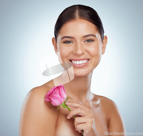 Image of Skincare, face and woman smile with rose in studio isolated on a white background. Portrait, natural flower and female model with pink floral plant for makeup cosmetics, beauty treatment and wellness