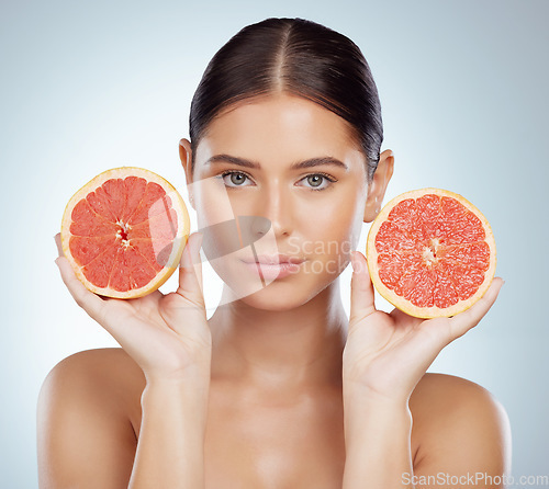 Image of Serious face, skincare and woman with grapefruit in studio isolated on white background. Portrait, natural and female model with fruit for vitamin c, nutrition or healthy diet, wellness or cosmetics.