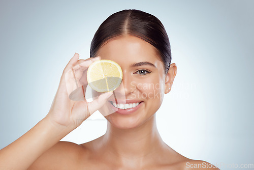 Image of Face, skincare and happy woman with lemon in studio isolated on a white background. Portrait, natural and female model with fruit for vitamin c, vegan nutrition or healthy diet, wellness or cosmetics