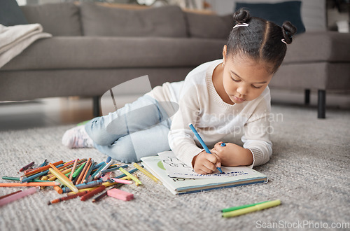 Image of Young girl, kid and pencils on floor with coloring book in living room for education, learning or creative development. Cute child, books and crayons for writing, drawing or creativity of art project