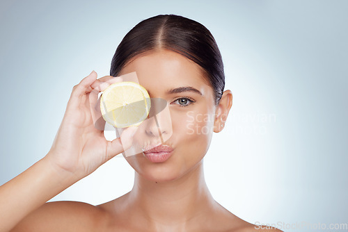 Image of Face kiss, skincare and woman with lemon in studio isolated on a white background. Portrait, natural and female model with fruit for vitamin c, nutrition or healthy diet, wellness or cosmetics pout.