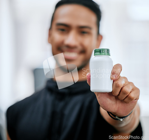 Image of Fitness drugs, hand and a man at the gym with a supplement for training and sport. Happy, portrait and an Asian athlete showing a bottle of medicine or vitamins for sports wellness and exercise