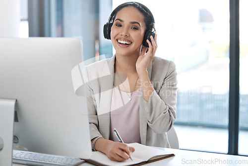 Image of Headphones, happy and portrait of business woman with smile listening to radio, song and audio in office. Corporate workplace, music and face of female worker writing notes, planning and schedule