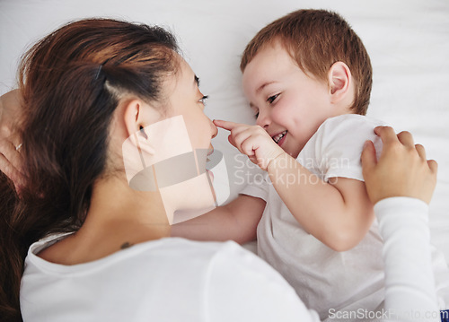 Image of Love, mother and baby in bed from above, happy and playing, bonding and talking in their home. Family, relax and top view of mom with toddler in a bedroom, wake up and smile while enjoying resting