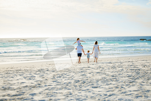 Image of Happy, holding hands and travel with family at beach for summer, vacation and bonding. Freedom, support and ocean with parents and children walking on seaside holiday for love, care and happiness