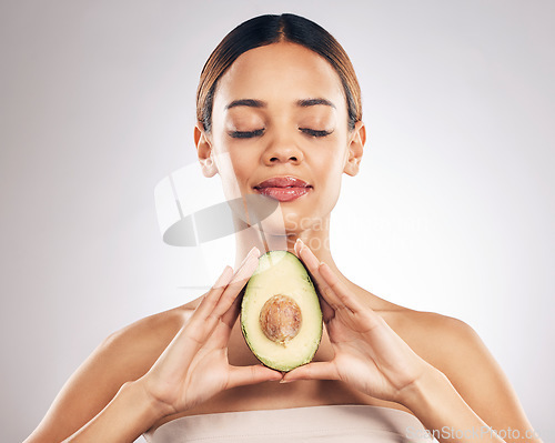 Image of Skincare, beauty and woman with avocado in studio for organic, facial or treatment on grey background. Face, glow and girl model with fruit for eco, vegan or skin detox with anti aging antioxidants