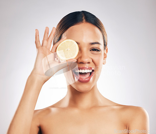 Image of Woman, lemon and studio portrait for beauty, wellness and excited with facial glow by white background. Girl, model and healthy skincare with youth, makeup and cosmetics for self care with funny face