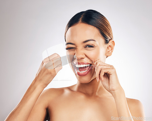 Image of Dental, portrait and happy woman flossing teeth in studio for hygiene, wellness and fresh breath on grey background. Face, floss and female relax with mouth, tooth and cleaning for oral care routine