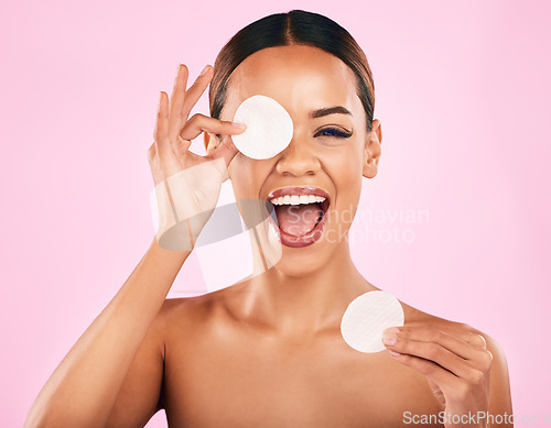 Image of Happy woman, face and cotton pad in skincare, makeup removal or cosmetics against a pink studio background. Portrait of excited female person with cosmetic swab in beauty cleaning or facial treatment
