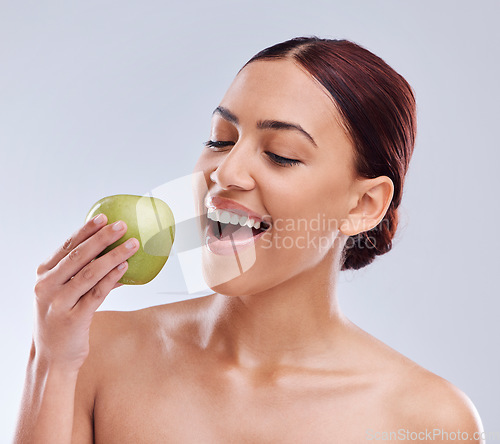 Image of Apple, happy or woman in studio eating on white background for healthy nutrition or clean diet. Bite, smile or hungry beautiful girl advertising or marketing natural organic green fruits for wellness